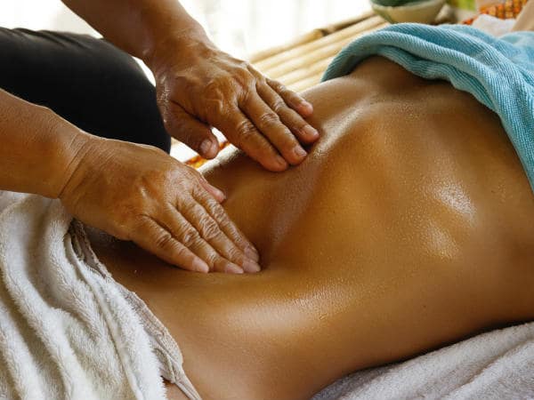 Massage bụng bằng dầu dừa.
